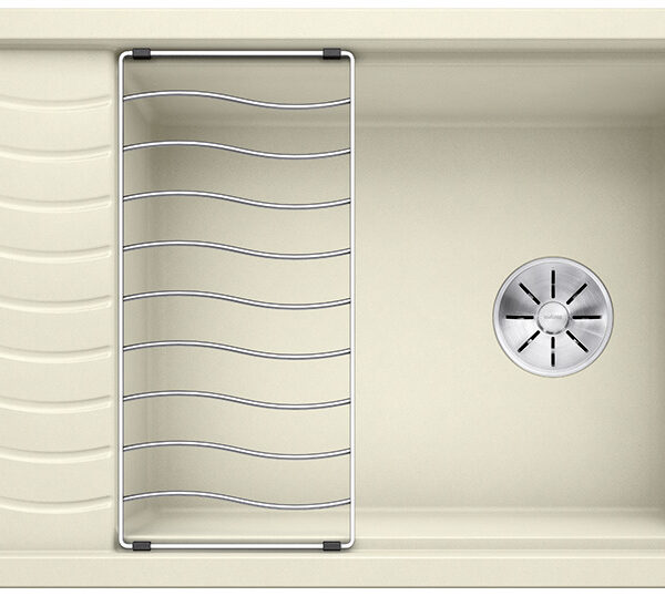 Beige kitchen sink with a metal dish rack resting inside and a wavy drainboard on the left side.