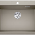 Beige kitchen sink with a centered stainless drain in the basin surface.