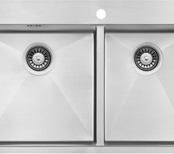 Double-basin stainless steel kitchen sink with two equal bowls and a faucet hole in the counter above.