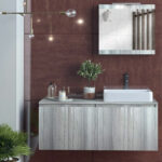 Floating light-grey wood vanity with white rectangular sink and tall chrome faucet against a brown tiled wall, mirrored cabinet above, and minimalist decor.