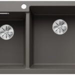 Gray double-basin kitchen sink with two round drains and a small circular hole along the top edge, shown from above.