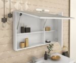 White bathroom cabinet with open shelves mounted above a sink, beige textured tile wall, and subtle gold accents.