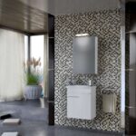 Modern bathroom with mosaic tiled wall, white vanity, mirror, and towel rack beside a window with a potted plant.