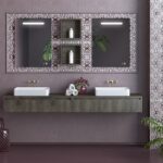 Double-sink bathroom vanity with a dark wood cabinet, ornate-framed mirror, and white vessel sinks on a purple wall.
