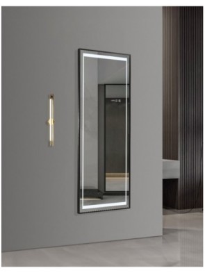 Rectangular backlit mirror on a gray wall in a modern interior, with a slender wall sconce to the left.