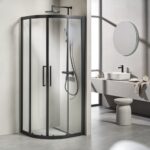 Curved glass corner shower enclosure with black frame in a modern bathroom.
