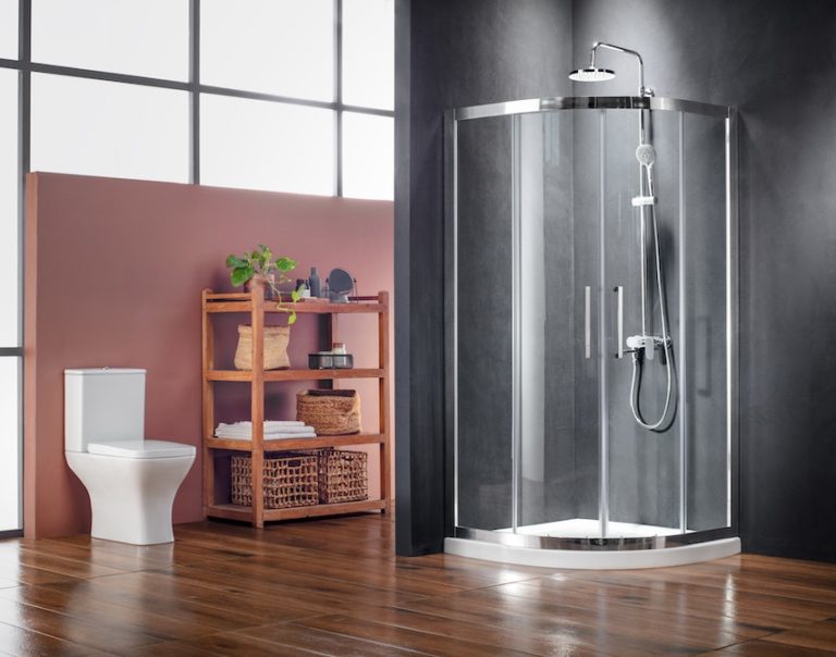 imikykliki1-e1585564610374-768x604 - Τσιντώνης Πλακάκια Contemporary bathroom with a white toilet, wooden towel shelf, and a curved glass shower enclosure on a dark wall.