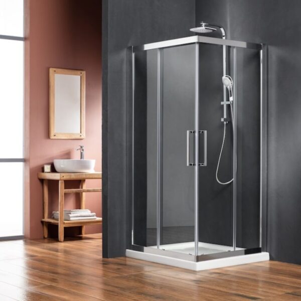 Glass shower enclosure with chrome frame in a modern bathroom, adjacent wooden vanity and mirror on the left.