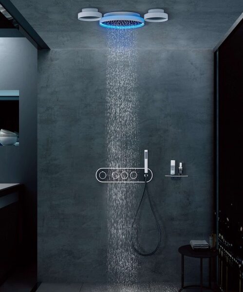 Modern shower with a circular ceiling rain head (blue ring light), water streaming onto a wall-mounted control rail and handheld shower.