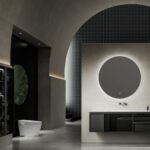 Minimalist bathroom with a round mirror above a gray floating vanity and a dark dotted wall.