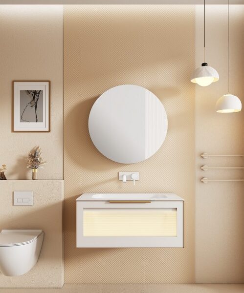 Beige minimalist bathroom with a floating vanity, backlit drawer, large round mirror, pendant lights, framed art, a small vase, and a wall-mounted toilet.
